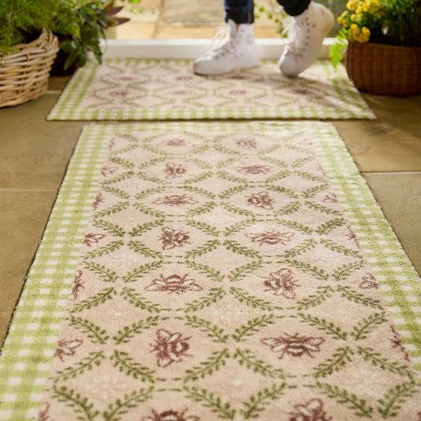 Beehive Green Charity Runner in Beige- a 100% recycled cotton runner featuring a white and green checked border and a collection of hand-painted bumblebees surrounded by a leafy garland.