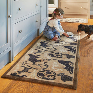 Lifestyle image of a girl and dog sar on a Hug Rug beige battersea dogs washable kitchen runner