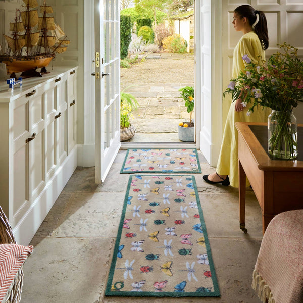 Bugs & Butterflies Beige Washable Runner in Beige- a 100% recycled cotton runner featuring a horizontal row of insects including butterflies, dragonflies, ladybugs, and beetles, in shades of blue, red, green, yellow, and white.