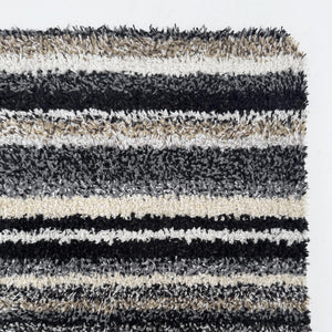 Candy Monochrome Washable Runner- a 100% recycled material runner featuring a subtle striped pattern in beige, grey, brown, black, and white.