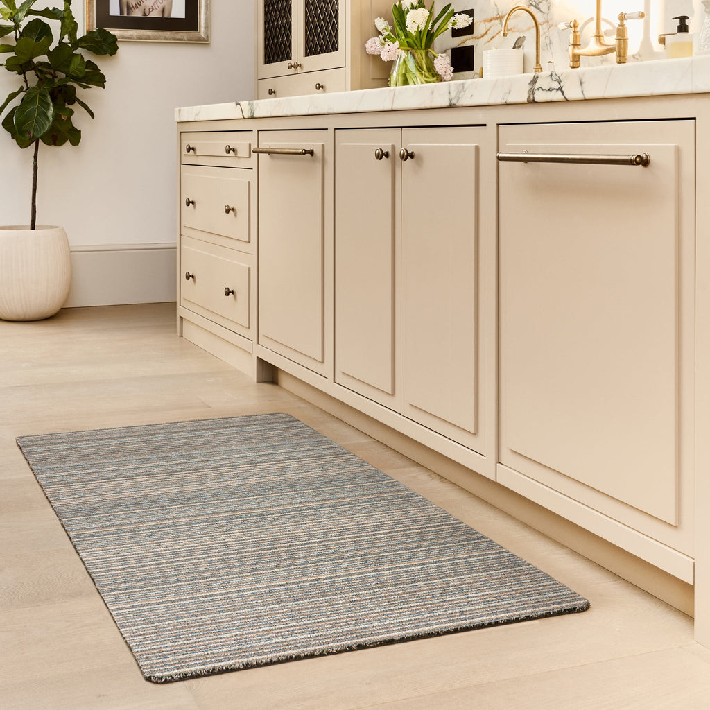 Candy Sand Striped Washable Runner- a 100% recycled material runner featuring a subtle striped pattern in shades of teal, beige, brown, white, and light grey.