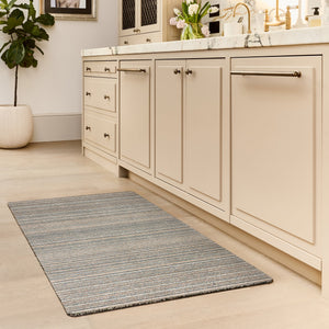 Candy Sand Striped Washable Runner- a 100% recycled material runner featuring a subtle striped pattern in shades of teal, beige, brown, white, and light grey.