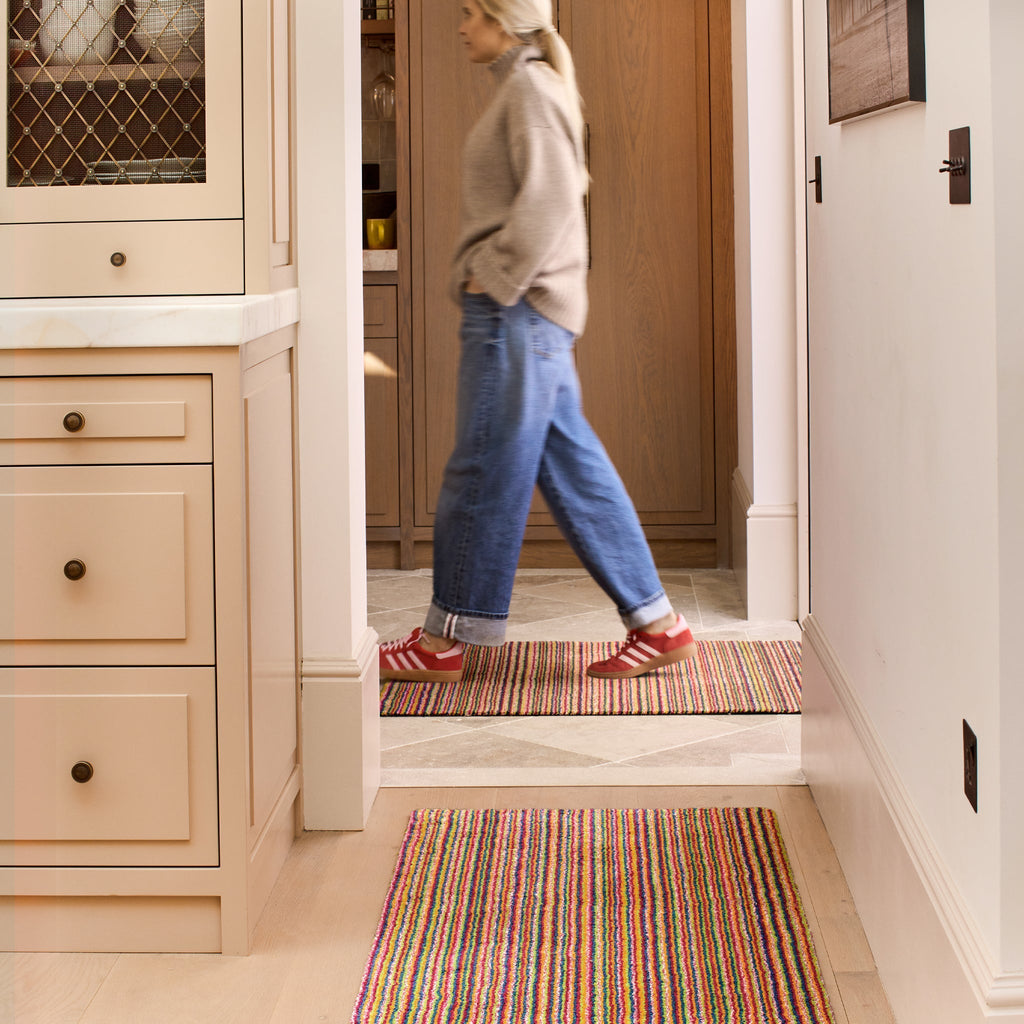 Candy Bright Stripe Washable Runner- a 100% recycled material runner featuring a striped pattern in shades of orange, red, beige, and grey.