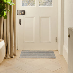 Candy Sand Stripe Washable Doormat- a recycled material doormat with a fleck design in the shades of teal, beige, brown, white, and light grey.