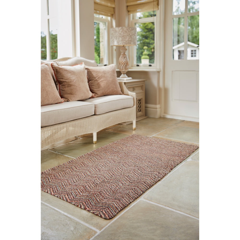 Candy Zig Zag Washable Runner- a 100% recycled material runner featuring a subtle zig-zag pattern in shades of red, beige, and navy, with a touch of white.