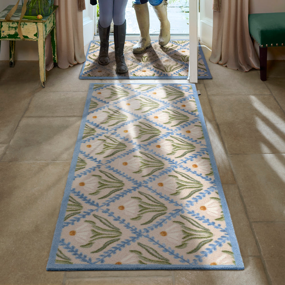 Daisy Trellis Washable Runner- a 100% recycled cotton runner featuring a daisy motif arranged within a trellis of blue, vine-like lines.