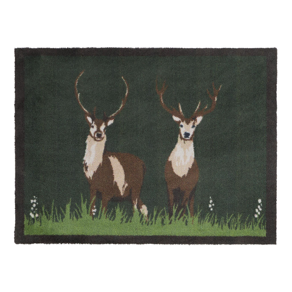 Green Deer Washable Doormat- a cotton doormat featuring two deers resting on green grass, surround by delicate white wildflowers.