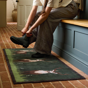 Green Deer Washable Runner in green- a 100% recycled cotton runner featuring three deer resting on green grass, surrounded by white wildflowers.