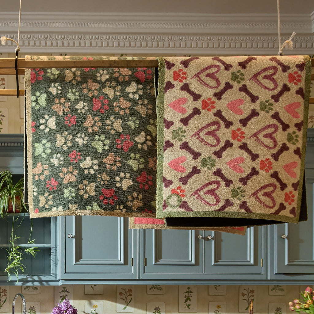 Hearts & Bones Runner - a 100% cotton runner featuring a pattern of bones, paw prints, and hearts in shades of burgundy, pink, green, and red.