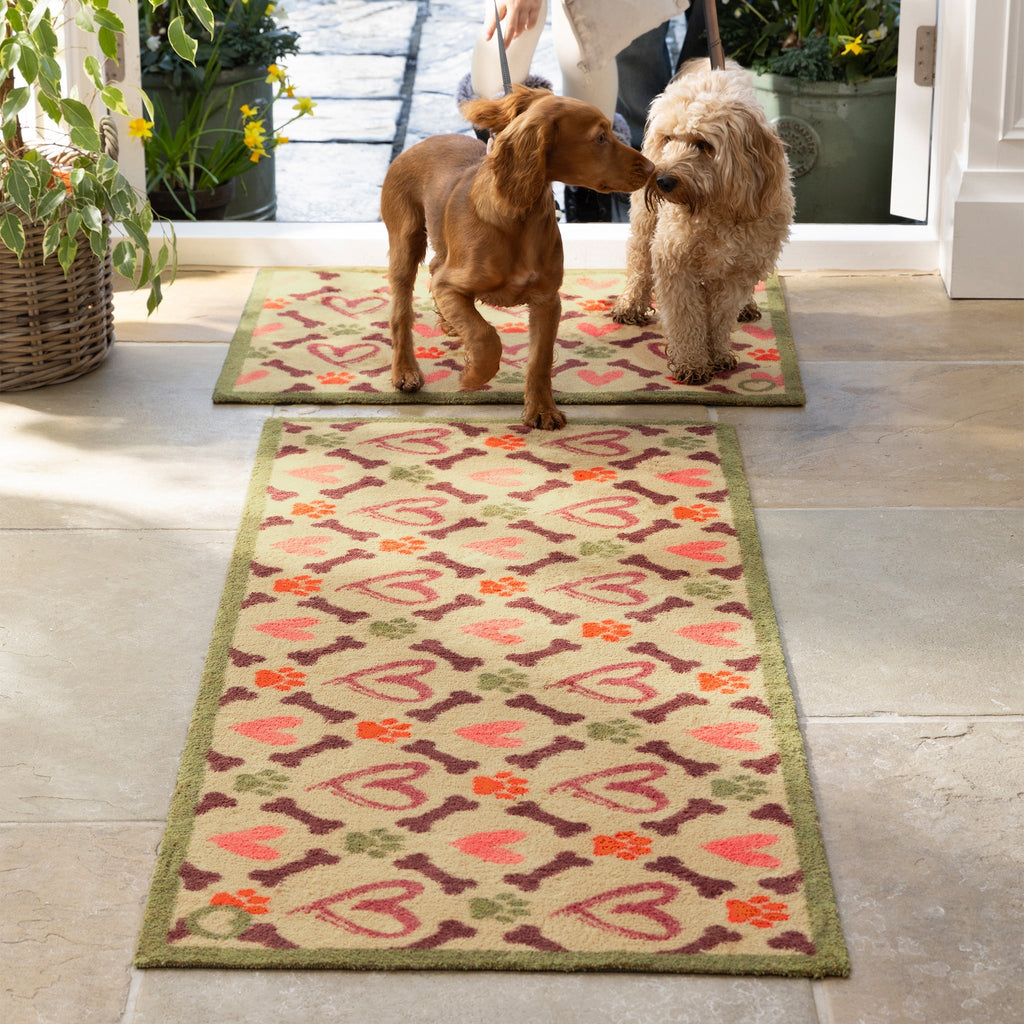 Hearts & Bones Runner - a 100% cotton runner featuring a pattern of bones, paw prints, and hearts in shades of burgundy, pink, green, and red.