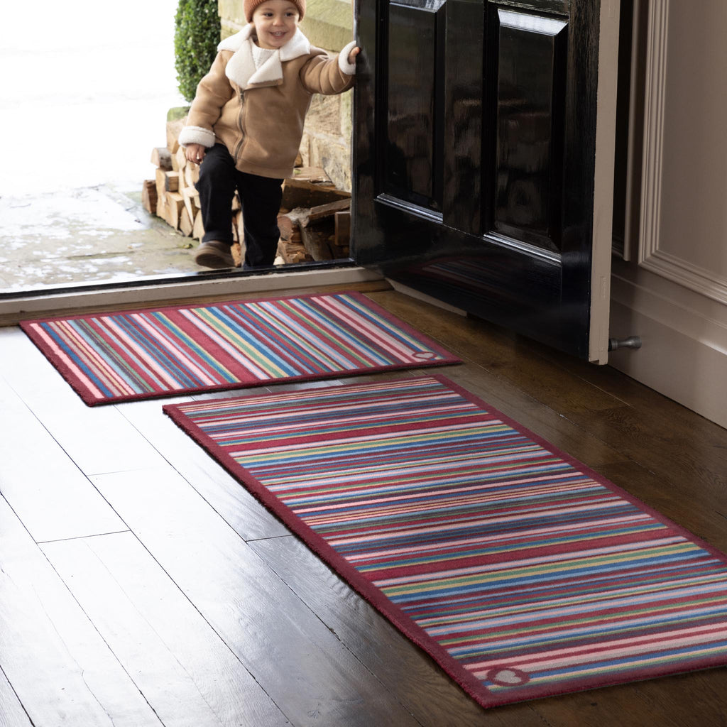 Multi Stripe Red Washable Runner- a 100% recycled cotton runner featuring vibrant stripes in pink, light blue, dark blue, grey, orange, and dark brown.