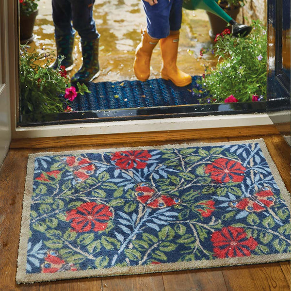 Nature 29 Washable Runner- a 100% recycled cotton runner featuring red flowers and butterflies surrounded by green and blue leaves.