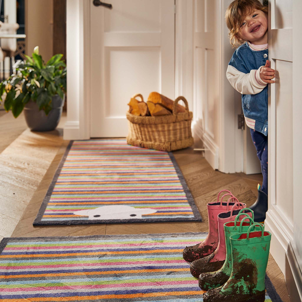 Peep Stripe Herdy Washable Runner- a 100% recycled cotton runner featuring a bright striped background with a Herdy peeking through the bottom of the mat.