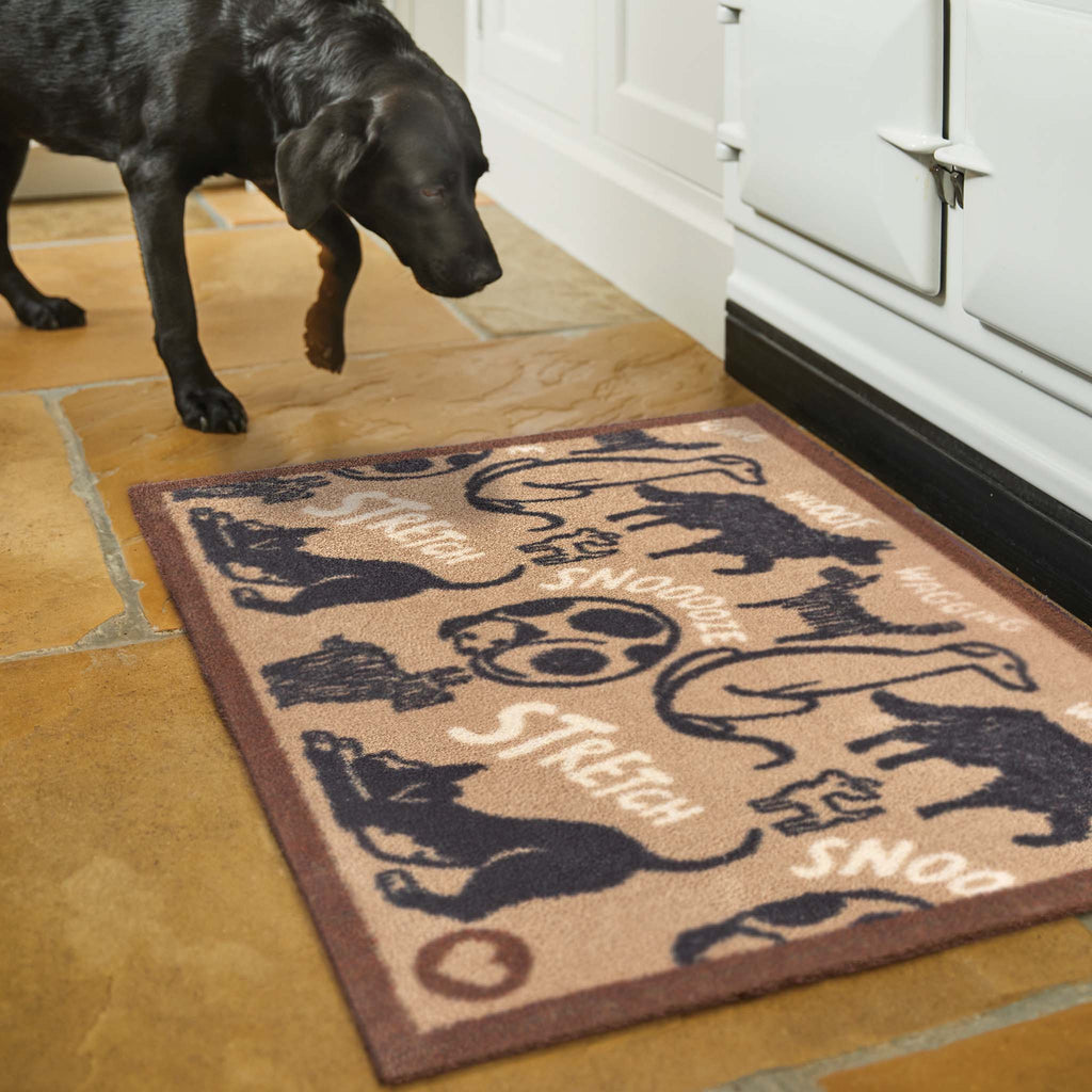 Lifestyle image of a dog and a beige battersea dogs washable kitchen mat