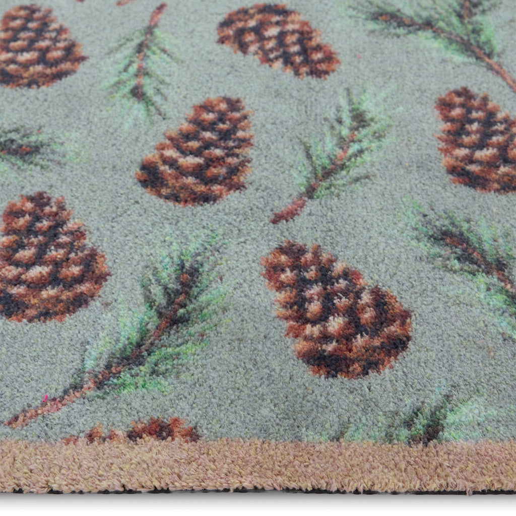 Pinecones Washable runner- 100% recycled cotton runner featuring scattered brown pinecones and green fern leaves.