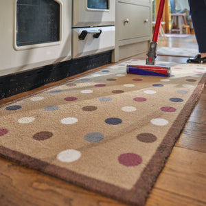 Spot 10 Brown Washable Runner in Brown- a 100% recycled cotton runner featuring an array of darker-toned spots in blue and red, accented with a few white and cream spots.