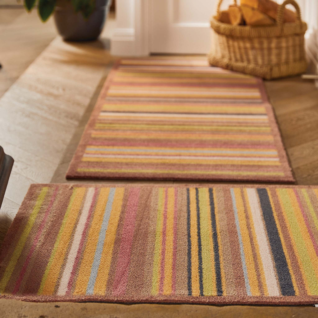 Stripe 70 Red/Blue Washable Runner- a 100% recycled cotton runner featuring vertical stripes in brown, green, red, orange, charcoal, and white.