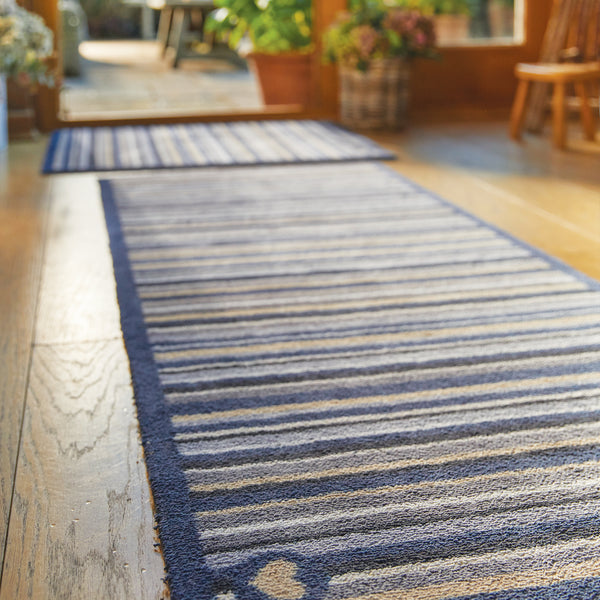 Stripe 88 Washable Runner- a 100% recycled cotton runner featuring an array of stripes in different shades of blue, grey, and beige.
