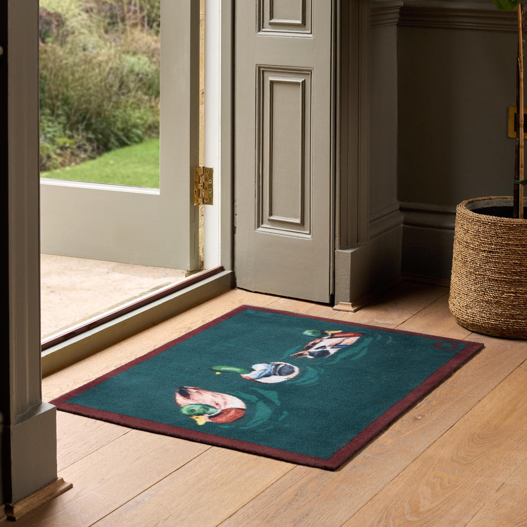 Swimming Ducks Teal Doormat – a teal cotton doormat featuring three swimming ducks.
