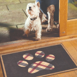Lifestyle image of a dog and Hug Rug black tartan paw washable doormat