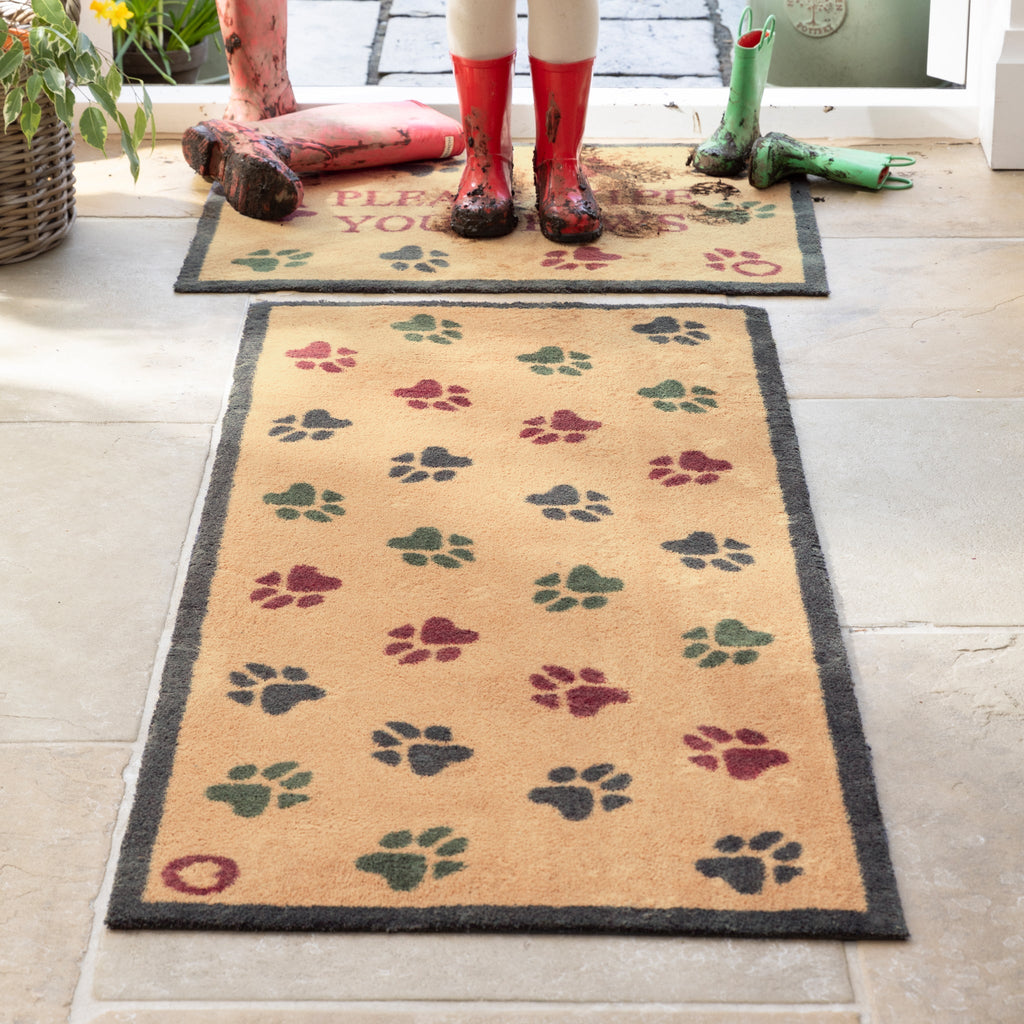 Lifestyle image of muddy wellies on Hug Rug beige wipe your paws washable doormat and washable runner