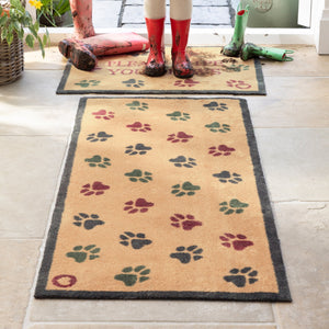 Lifestyle image of muddy wellies on Hug Rug beige wipe your paws washable doormat and washable runner