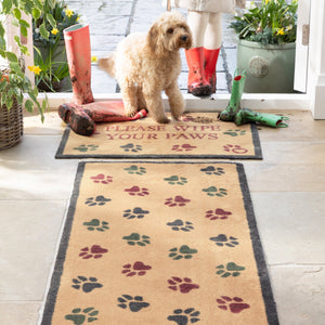 Wipe your Paws Beige Washable Runner in beige- a 100% recycled cotton runner featuring scattered paw prints in charcoal, dark green, and burgundy.