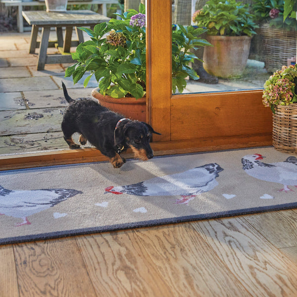 Chicken 1 Beige Washable Runner- a 100% recycled cotton runner featuring three white and grey chickens pecking at scattered white hearts. 