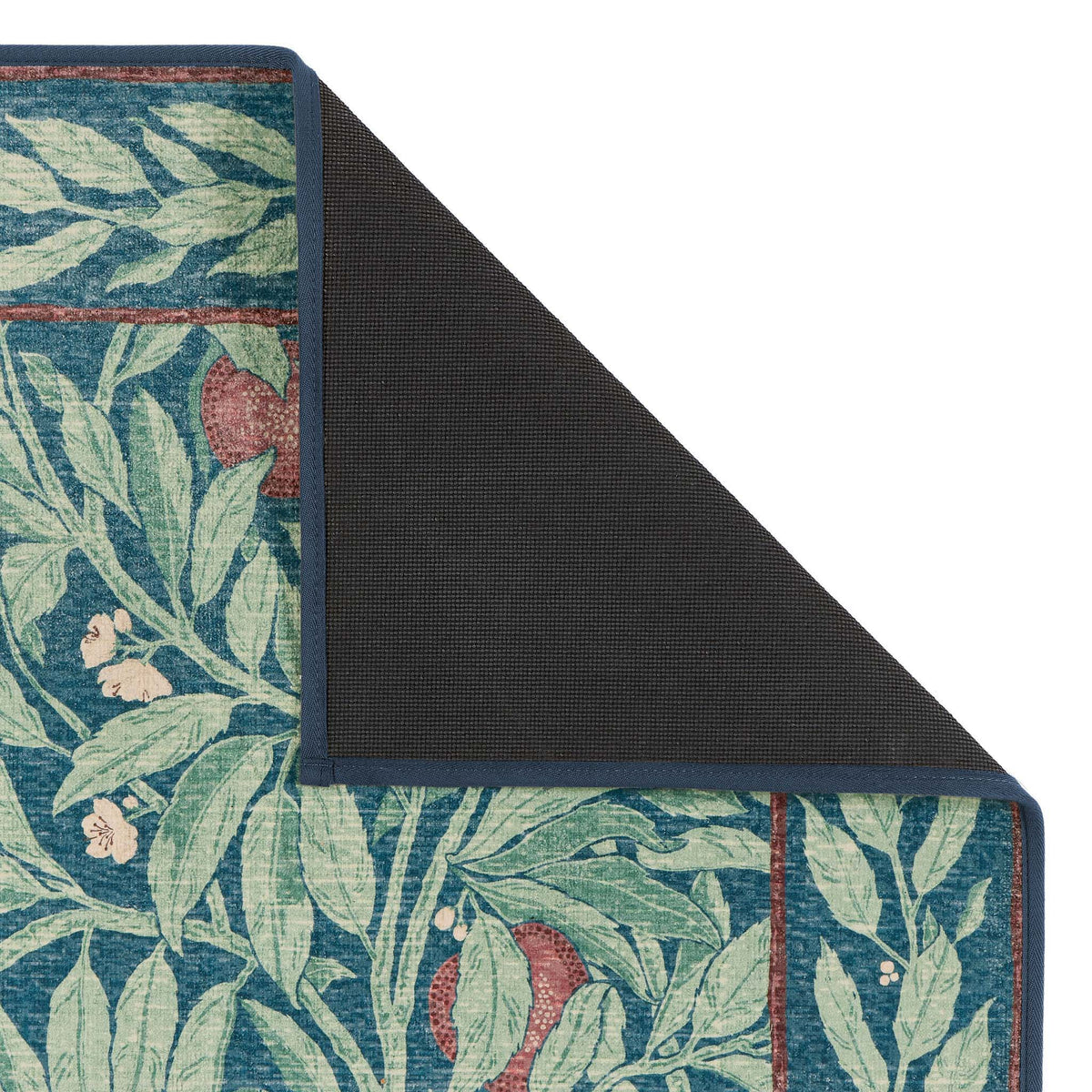 Close-up of Ancient Apple Tree Midnight Eco-Washable Rug with apple tree design showing rubber backing.