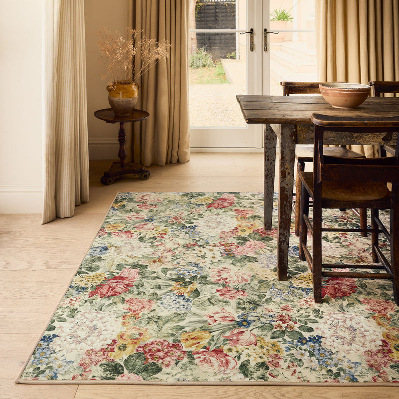 Antique Hydrangea & Rose Chintz Eco-Washable Rug with a floral design, styled under a wooden kitchen table.