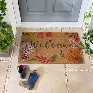 Discover the Autumnal Welcome Coir Doormat- a coir doormat featuring leaves, berries, pumpkins and mushrooms with a graphic font. 