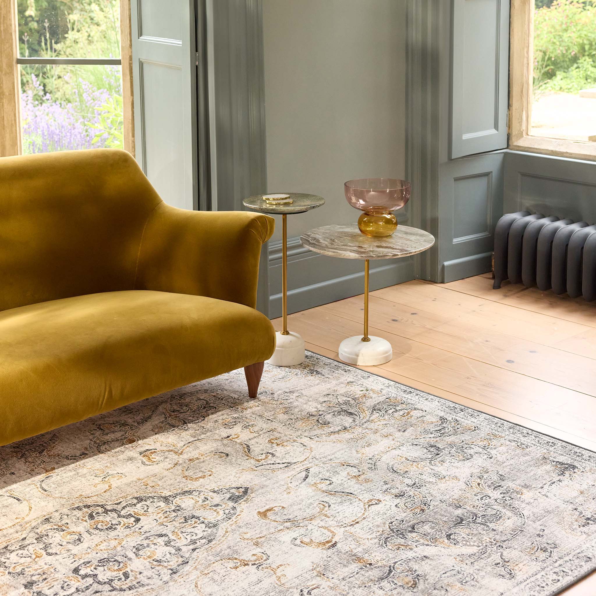 Baroque Eco‑Washable Rug with a textured ornate pattern, styled in a living room. 