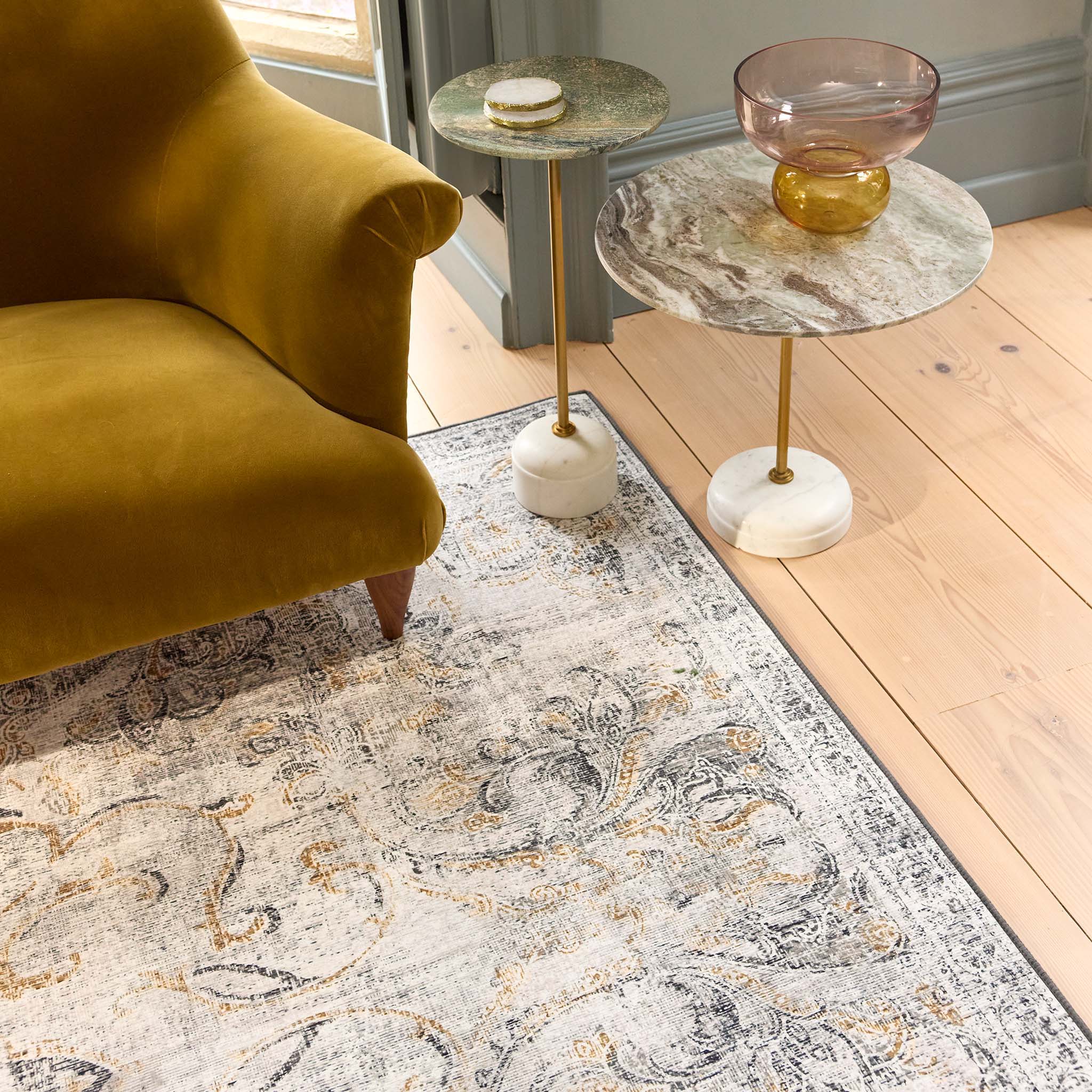 Baroque Eco‑Washable Rug with a textured ornate pattern, styled in a living room. 