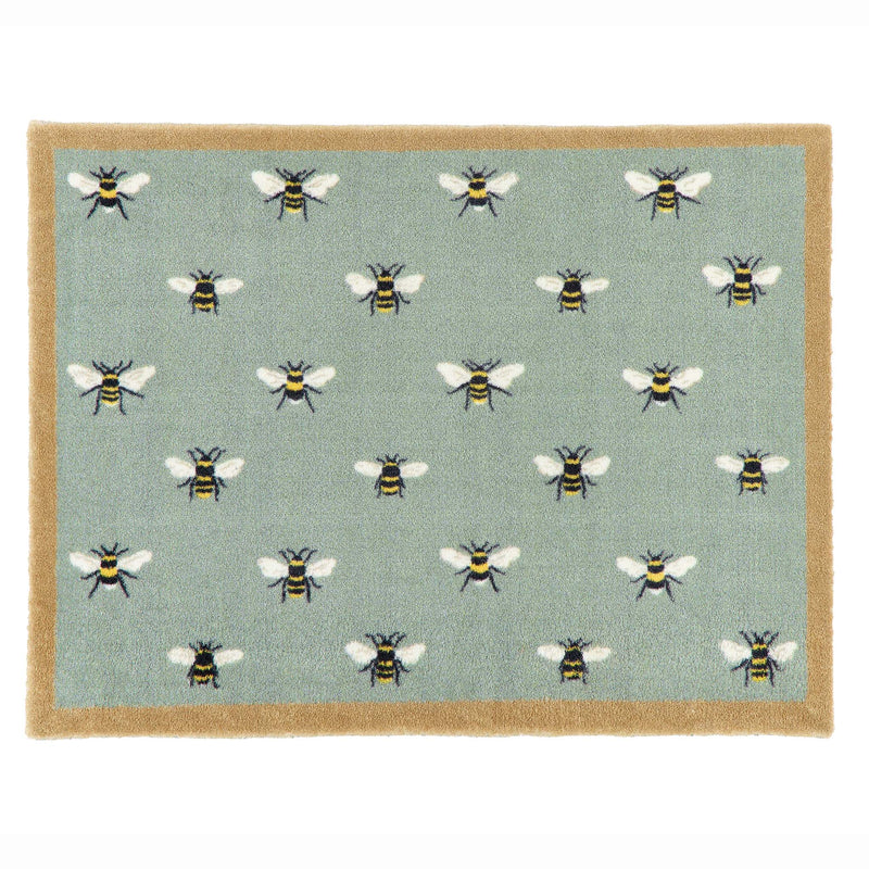 A rectangular doormat with a sage green background featuring a repeating pattern of bumblebees, finished with a natural coloured border.