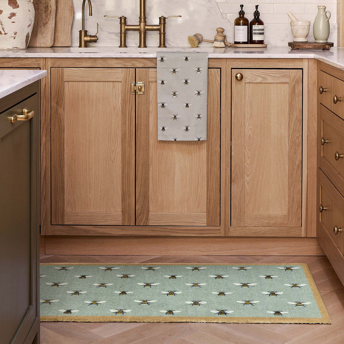 a teal runner with a bee patten in a modern kitchen by the sink.