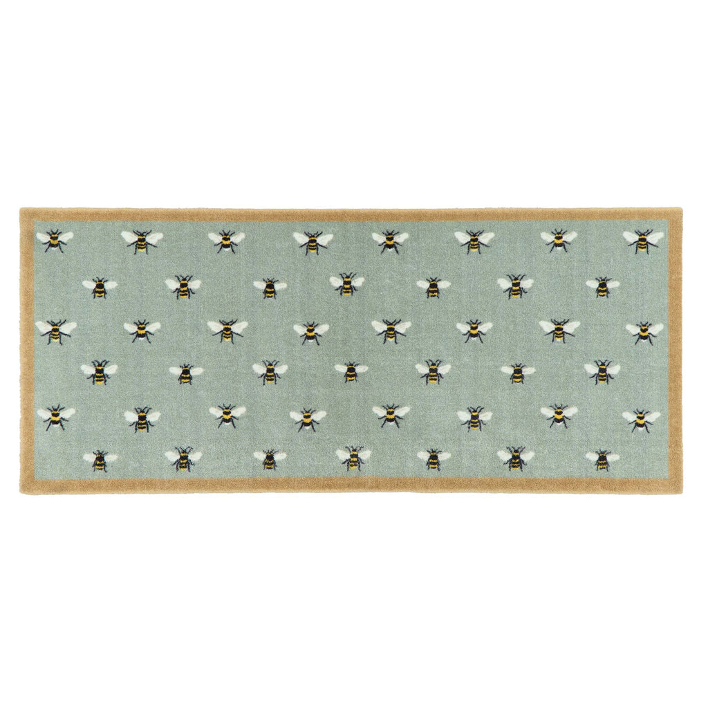 A rectangular area runner with a light sage green background featuring a repeating pattern of bumblebees, finished with a natural colour border.