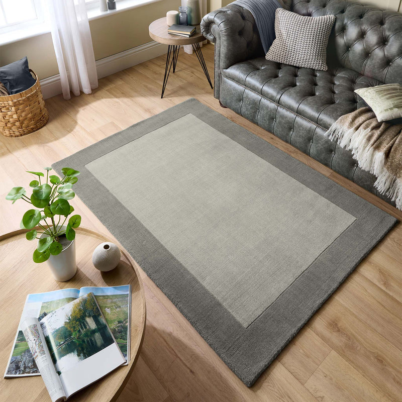 Borders Grey 100% wool rug with a two-tone border design, styled in a living room.