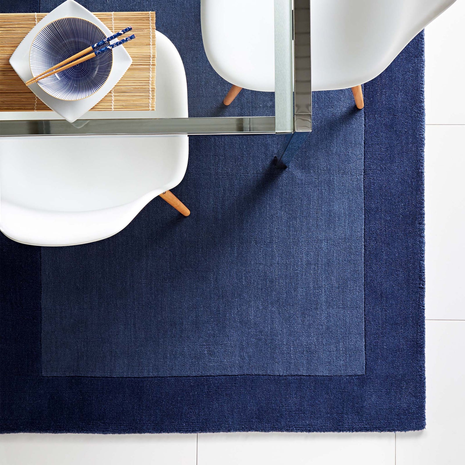 Borders Navy Blue 100% wool rug with a two-tone border design, styled in a dining room.