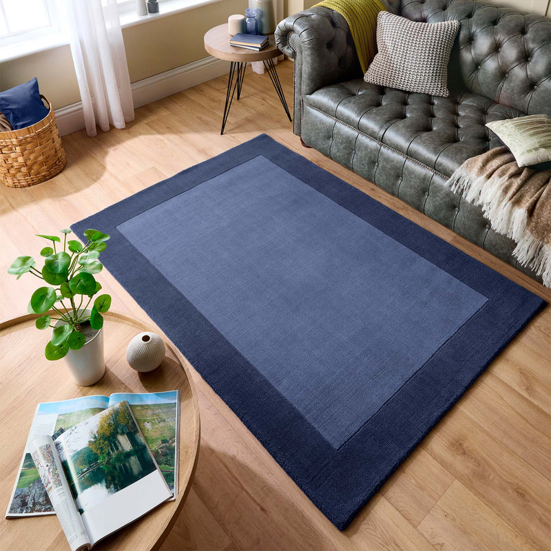 Borders Navy Blue 100% wool rug with a two-tone border design, styled in a living room.