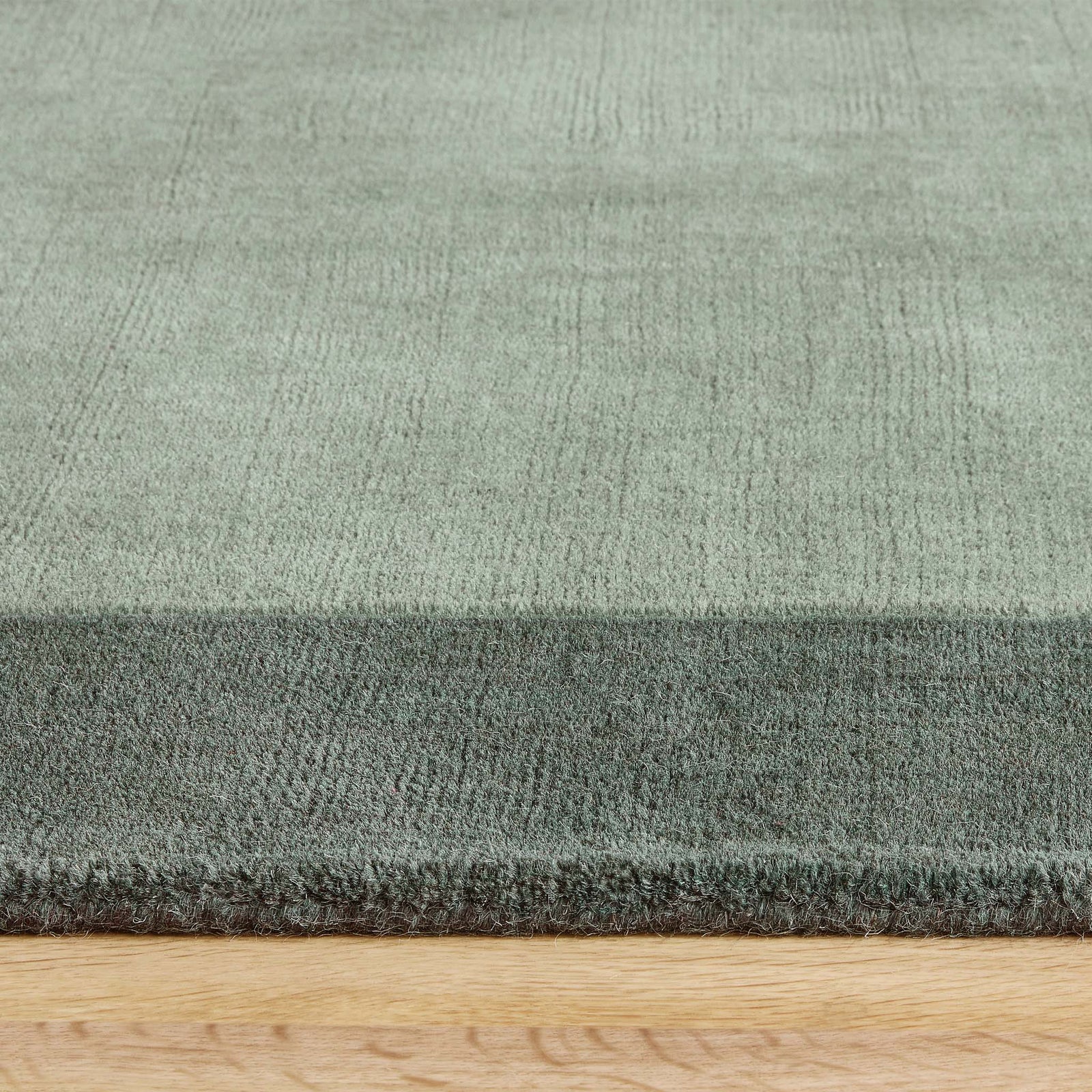 Borders Sage Green Rug - 100% wool rug in light green with a darker green border. 