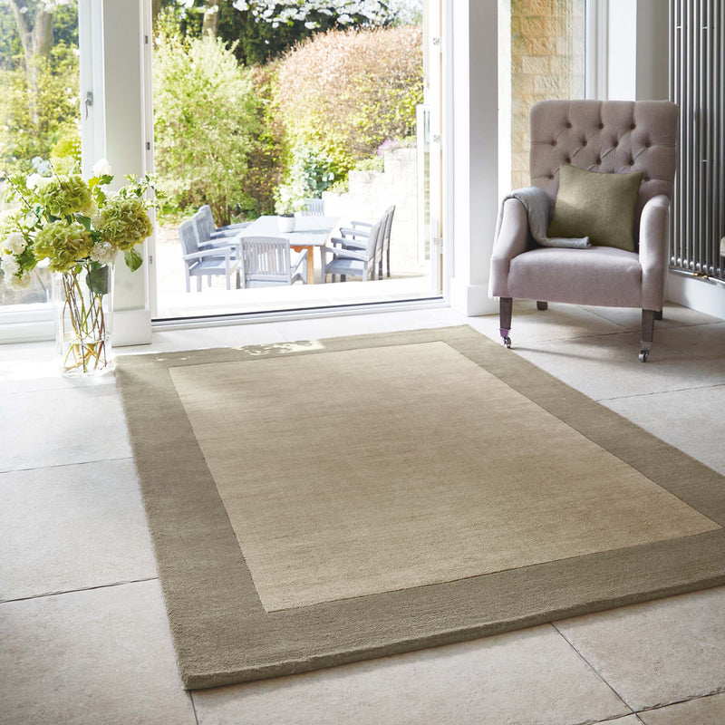 Borders Taupe Brown 100% wool rug with a two-tone border design, styled in a conservatory.
