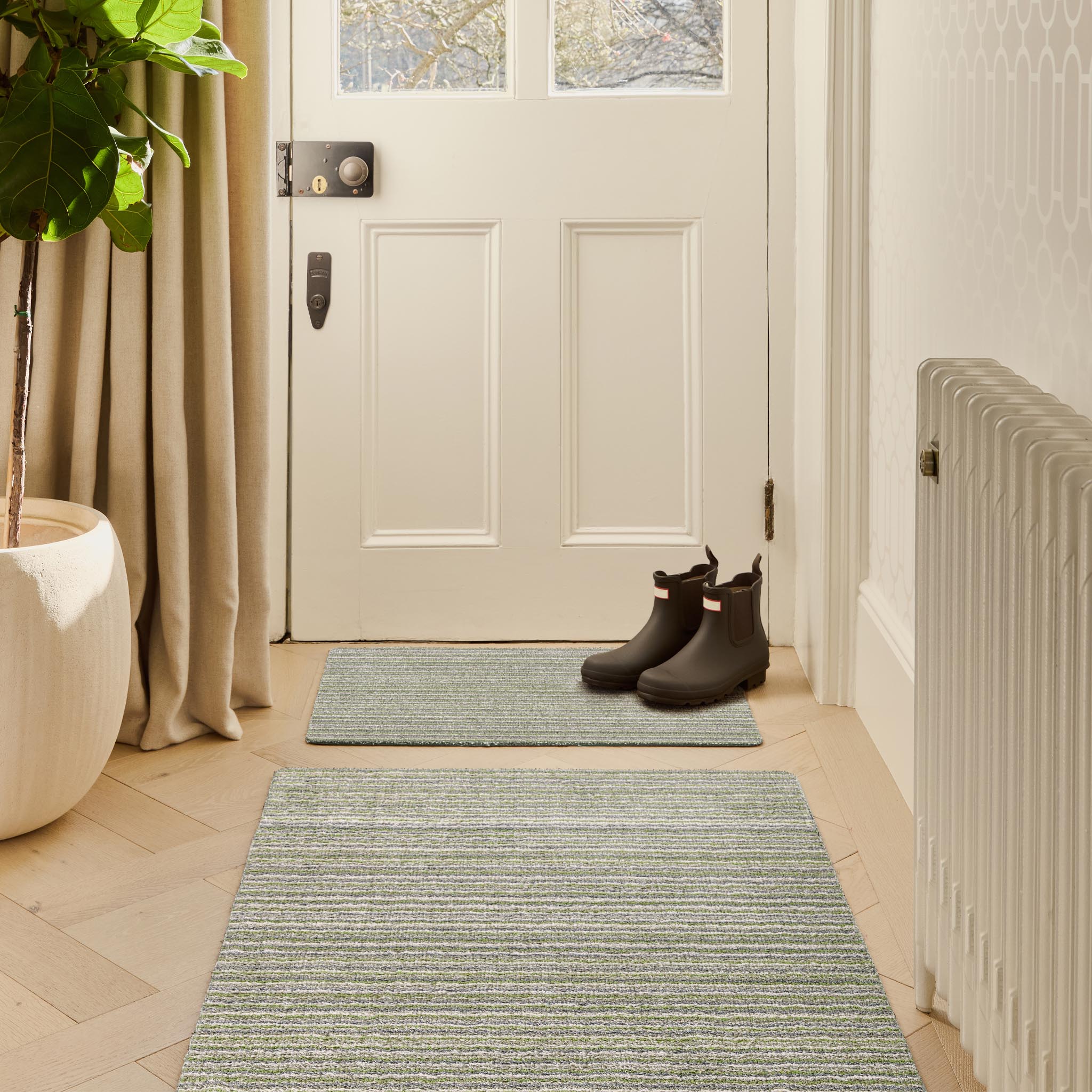 Candy Green Washable Doormat with a stripe design, styled in a doorway.