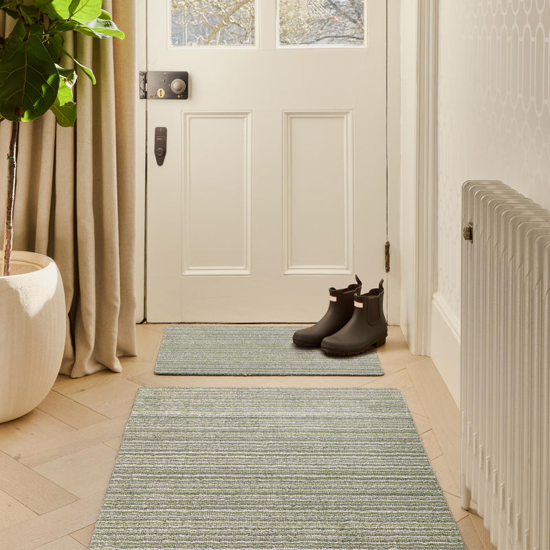 Candy Green Washable Doormat with a stripe design, styled in a doorway.