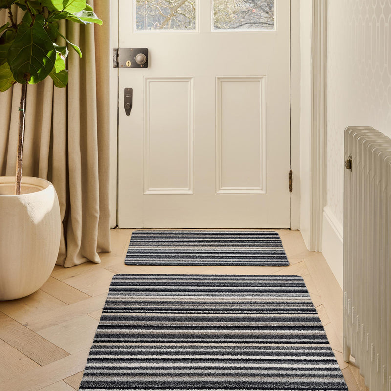 Candy Monochrome Washable Runner- a 100% recycled material runner featuring a subtle striped pattern in beige, grey, brown, black, and white. .
