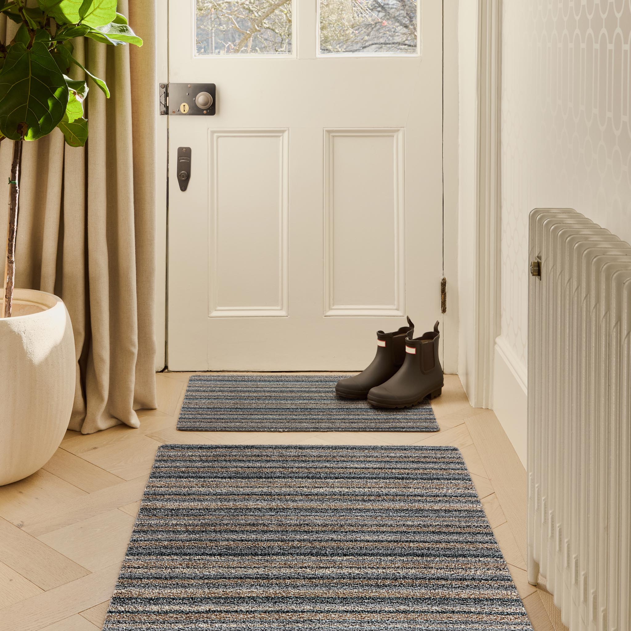 Candy Ribbon Grey Doormat with a stripe design, styled in a entryway.