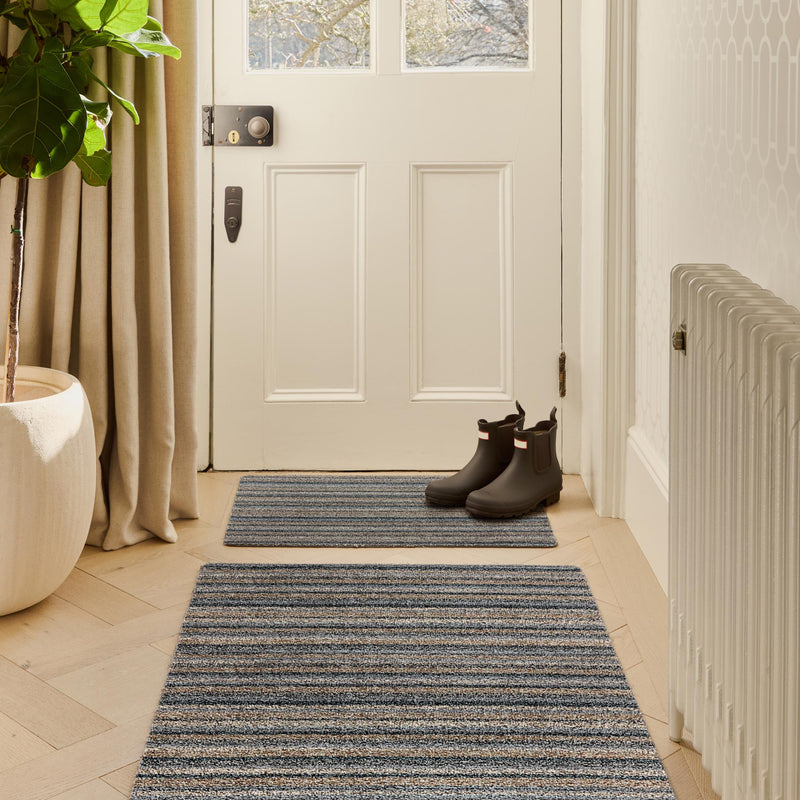 Candy Ribbon Grey Doormat with a stripe design, styled in a entryway.