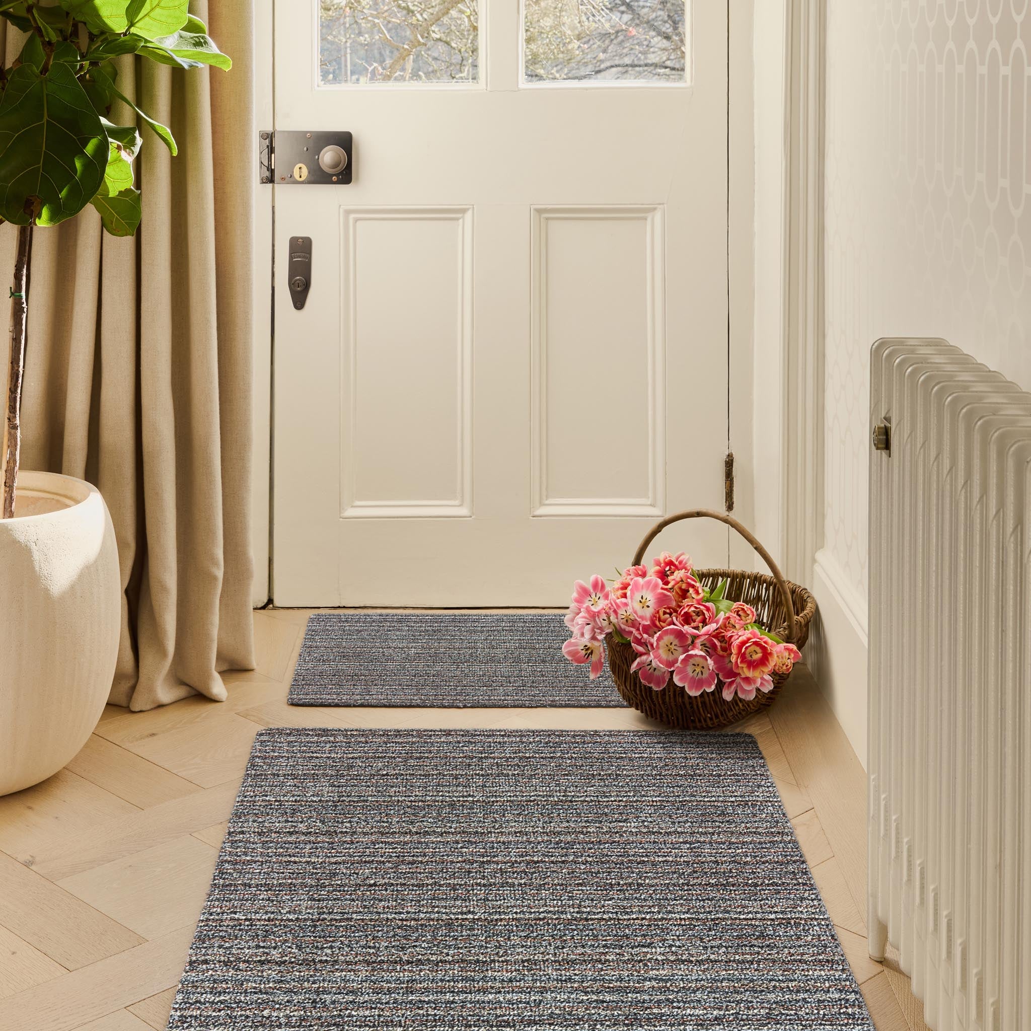 Candy Rocks Stripe Grey Doormat with a stripe design, styled in a entryway. 