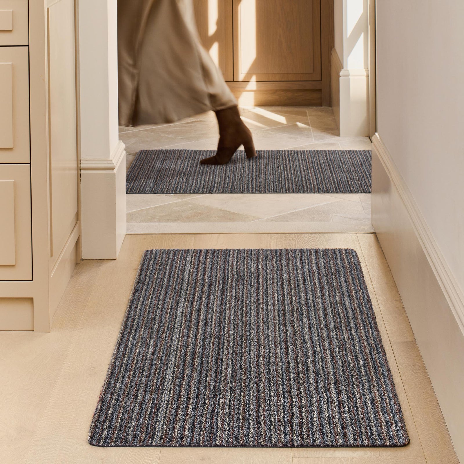 Candy Rocks Striped Washable Runner- a 100% recycled material runner featuring a subtle striped pattern in shades of beige, grey, and orange. 