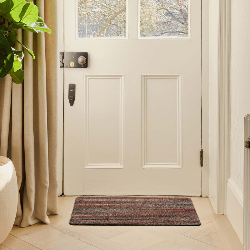 Candy Stripe Doormat with a striped design, styled in a doorway.
