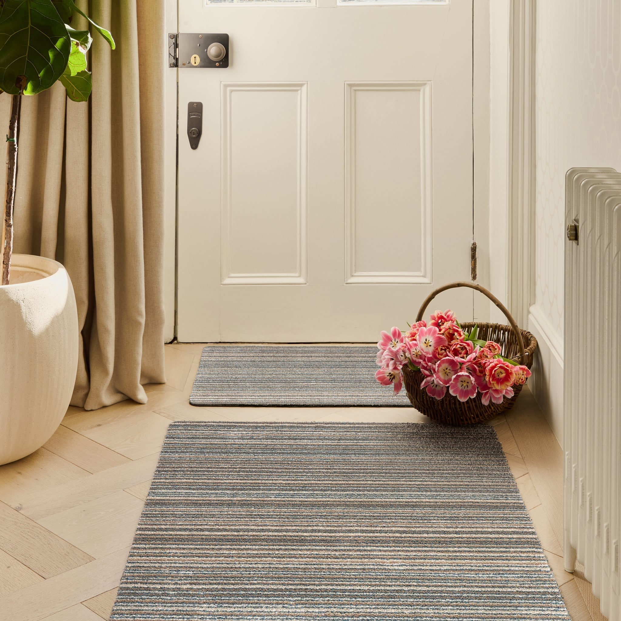 Candy Sand Striped Washable Runner- a 100% recycled material runner featuring a subtle striped pattern in shades of teal, beige, brown, white, and light grey.